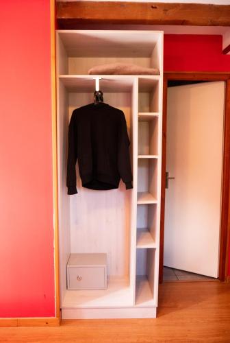 a black shirt is hanging in a closet at Hotel Chalet du Crey in Valmorel
