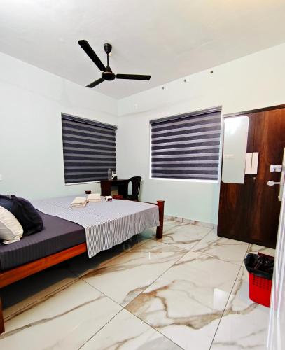 a bedroom with a bed and a ceiling fan at Happy Buddha Varkala in Varkala