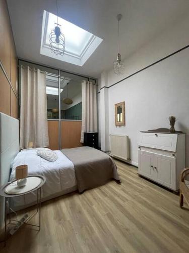 a bedroom with a bed and a table in it at Appartement au centre de Boulogne-sur-Mer in Boulogne-sur-Mer