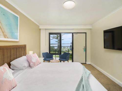 a bedroom with a large bed and a television at ibis Styles Port Macquarie in Port Macquarie