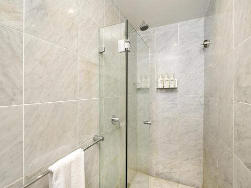 a shower with a glass door in a bathroom at ibis Styles Port Macquarie in Port Macquarie