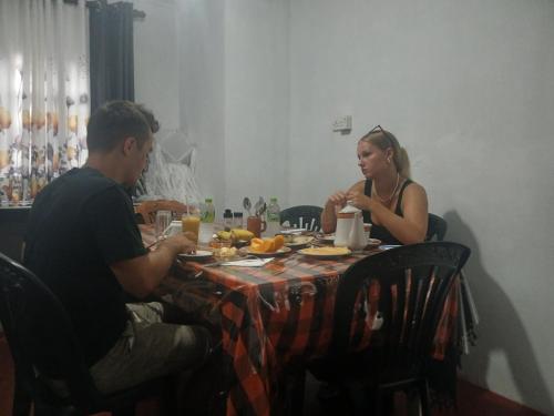 a man and woman sitting at a table eating food at Dio Green House NUWRA ELIYA in Nuwara Eliya