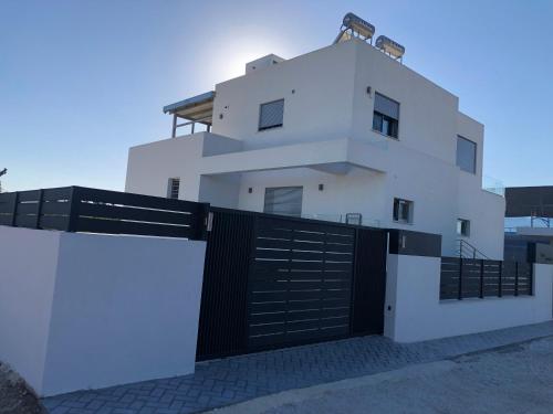 a white house with a black gate at Toska Residence in Loutraki
