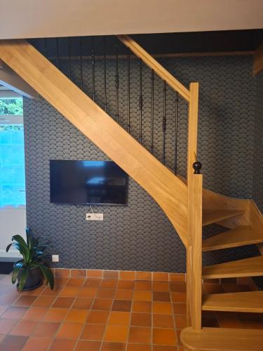 a living room with a staircase and a tv at La Glycine in Luçon