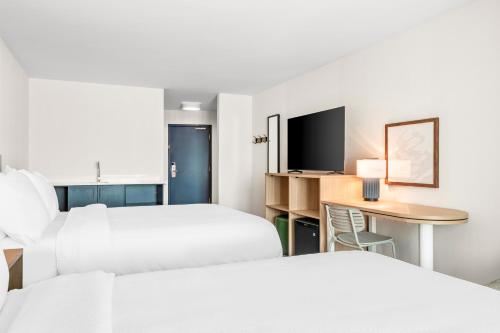 a hotel room with two beds and a desk at Inn at Philadelphia Airport in Philadelphia