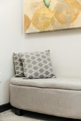 a pillow sitting on a couch under a painting at Stylish Vibes 1BD in WEHO in Los Angeles