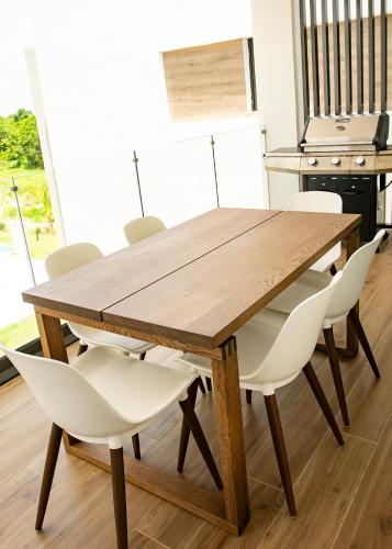 a wooden table with white chairs and a kitchen at Cana Cove in Punta Cana