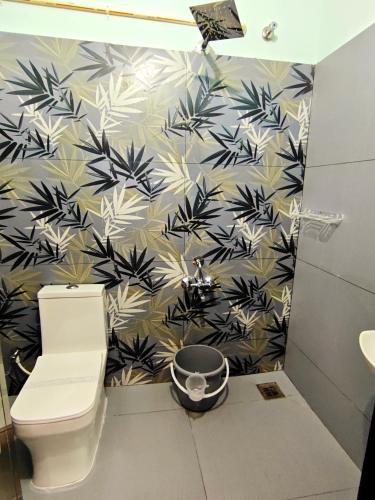 a bathroom with a toilet and a black and white wallpaper at Happy Buddha Varkala in Varkala