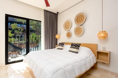 a bedroom with a white bed and a large window at Amira District in Cedro