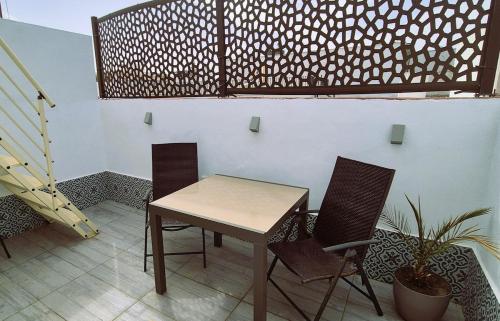 a table and two chairs in a room at Ático de Goleta by Gades Gestión in Cádiz