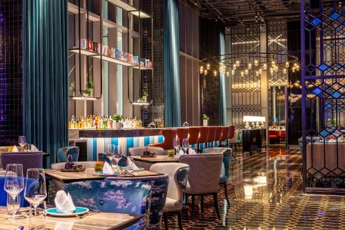 a restaurant interior with tables and chairs and lights at InterContinental Chongqing Raffles City by IHG in Chongqing