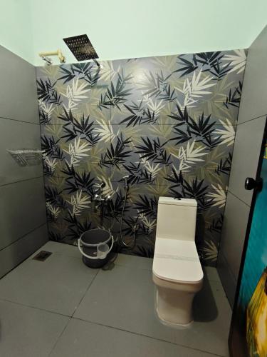 a bathroom with a toilet and a black and white wallpaper at Happy Buddha Varkala in Varkala