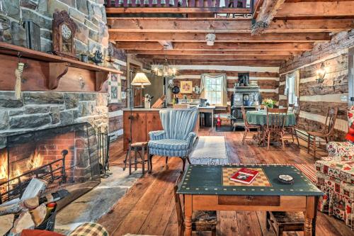 a living room with a stone fireplace and a table at Cabin Vacation Rental about 8 Mi to Penn State! in State College