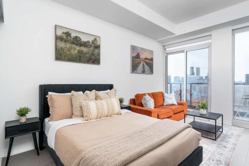 1 dormitorio con 1 cama y 1 silla naranja en Stylish Cozy Studio Condo Downtown, en Toronto