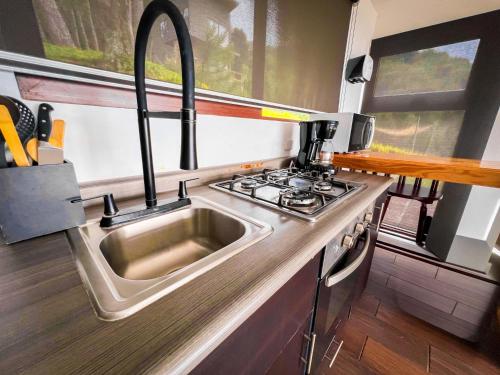 a kitchen with a sink and a stove at VIU Boutique Cabins in San Salvador