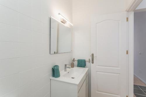 a white bathroom with a sink and a mirror at Apartamento lucas in La Aldea de San Nicolas