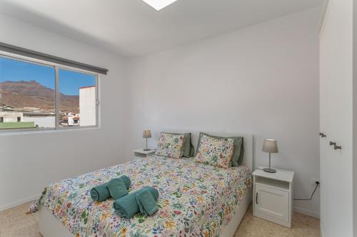a bedroom with a bed with pillows and a window at Apartamento lucas in La Aldea de San Nicolas