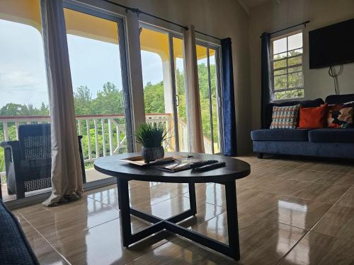 a living room with a coffee table and a balcony at Royal Escape - 2 in Anse La Raye