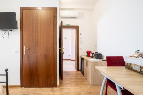 a kitchen with a wooden door and a table at Agriturismo Al Tralcio in Valeggio sul Mincio