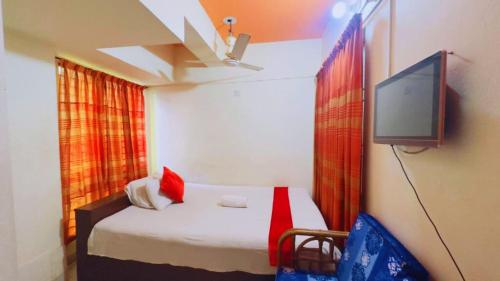 SolpurにあるHotel The Sylhet Internationalのテレビとベッドのある部屋、ベッドスカート付き ...