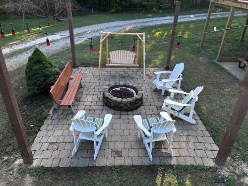 un gruppo di sedie e un braciere con una panca di Luxury Spacious Cabin Hot Tub, Theater, 5 Acres in Hocking Hills a Logan
