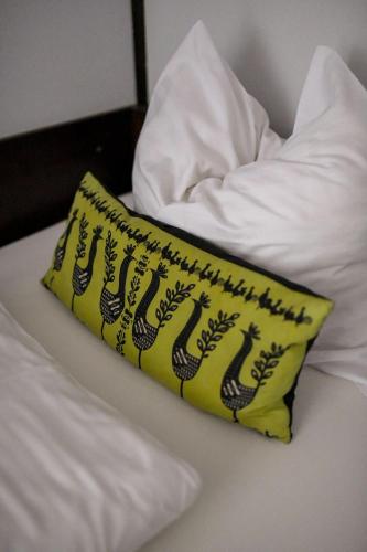 a yellow pillow sitting on top of a bed at Hotel Zodiak in Radomsko