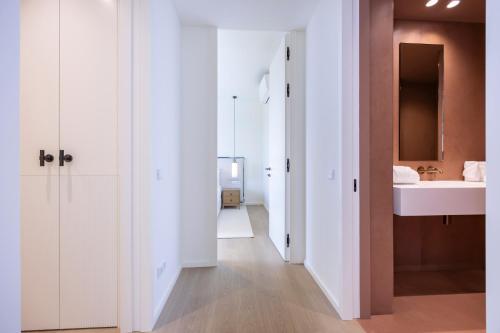 baño con puertas blancas y lavamanos en The Editory Residence Lagos, en Lagos