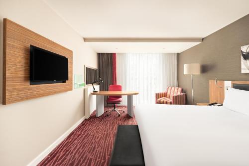 a hotel room with a bed and a table and a television at Holiday Inn Manchester-Mediacityuk by IHG in Manchester