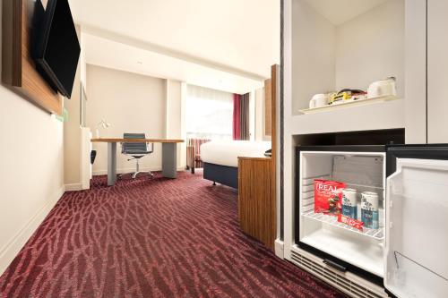 a hotel room with a refrigerator and a bed at Holiday Inn Manchester-Mediacityuk by IHG in Manchester
