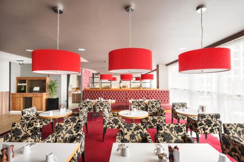 a restaurant with tables and chairs and red walls at Holiday Inn Manchester-Mediacityuk by IHG in Manchester