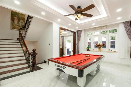 a pool table in a living room with a ceiling at Kai Verde Villa in Ho Chi Minh City