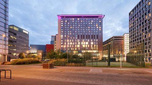 a tall building in the middle of a city at Holiday Inn Manchester-Mediacityuk by IHG in Manchester