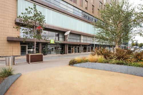 a building with a courtyard in front of it at Holiday Inn Manchester-Mediacityuk by IHG in Manchester