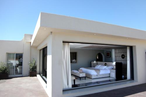 a bedroom with a bed and a large window at Hôtel Marinca & Spa in Olmeto
