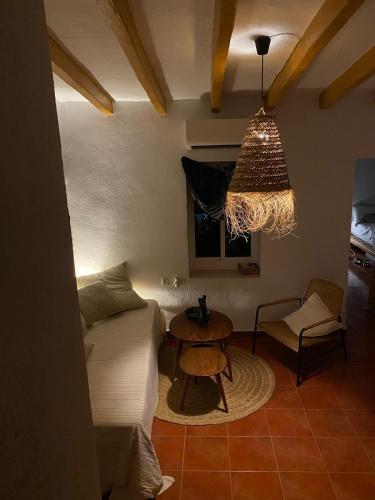 a bedroom with a bed and a table and a chair at Casa luz in Viñuela