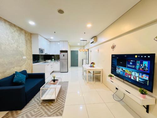 a living room with a large flat screen tv at Luxury Summer Suites KLCC By LEXA Stay in Kuala Lumpur