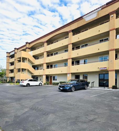 two cars parked in front of a large building at Border Plaza Hotel in San Diego