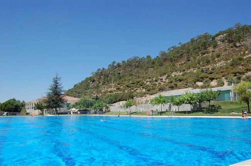 a large blue swimming pool with a mountain in the background at Casa Tatas Precioso piso recién reformado in El Barraco