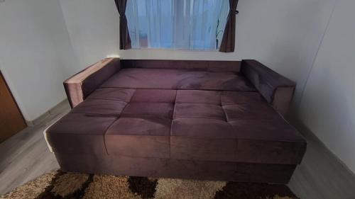 een groot bruin bed in een kamer met een raam bij Casa Bianchi Vatra Dornei in Vatra Dornei
