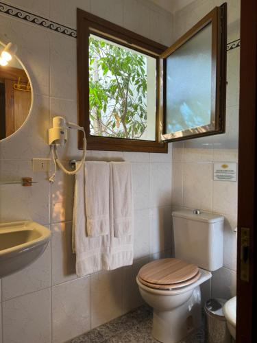 a bathroom with a toilet and a sink and a window at HOUSES CASA LA TOSCA The Best views in Tejeda