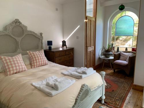 a bedroom with a bed with towels on it at Crow Cottage in Briston