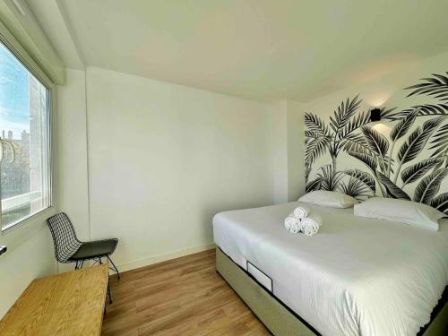 1 dormitorio con 1 cama con un mural de plantas en la pared en Appartement Parking Metro, en Caluire-et-Cuire