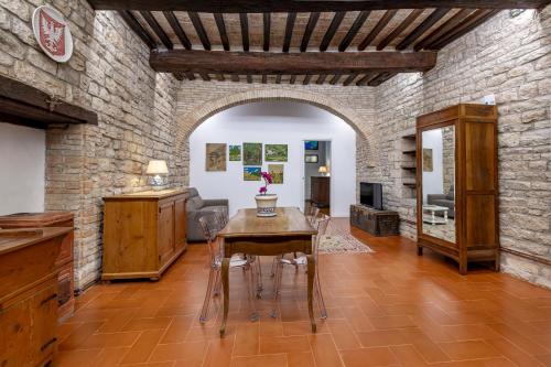 a living room with a table and a brick wall at B&B Shahrazad in Gubbio