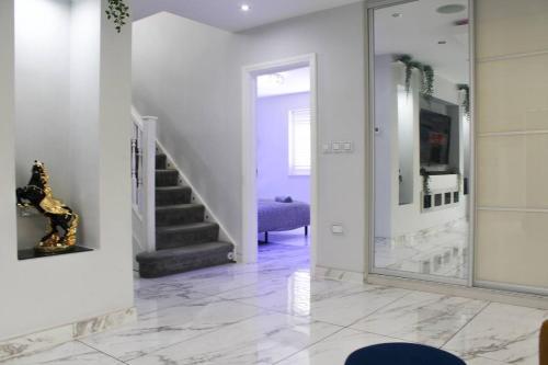 a hallway with a staircase and a mirror at Falcon house 7 bedrooms in Hawley