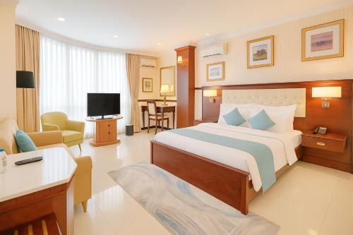 a bedroom with a large bed and a living room at S79 Vuon Saigon Hotel & SPA in Ho Chi Minh City