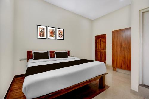a bedroom with a large bed in a room at Hotel O Sri Lakshmi Dev's Comfort in Shrīrangapattana
