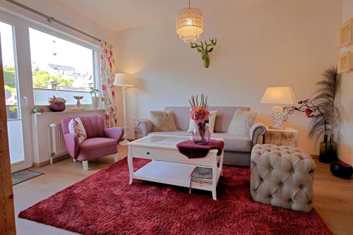 a living room with a couch and a table at Upland-Flair Ferienwohnung BLUMENWIESE im Zentrum! in Willingen