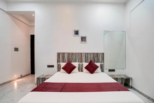 a bedroom with a white bed with red pillows at Viva villa by Dancenter in Malavli