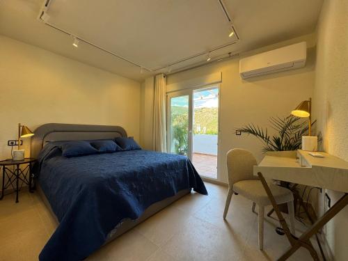 a bedroom with a bed and a desk and a window at Atico Benahavis in Benahavís