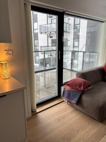 a living room with a couch and a large window at Luxury Seaside Apartment Tromsø in Tromsø